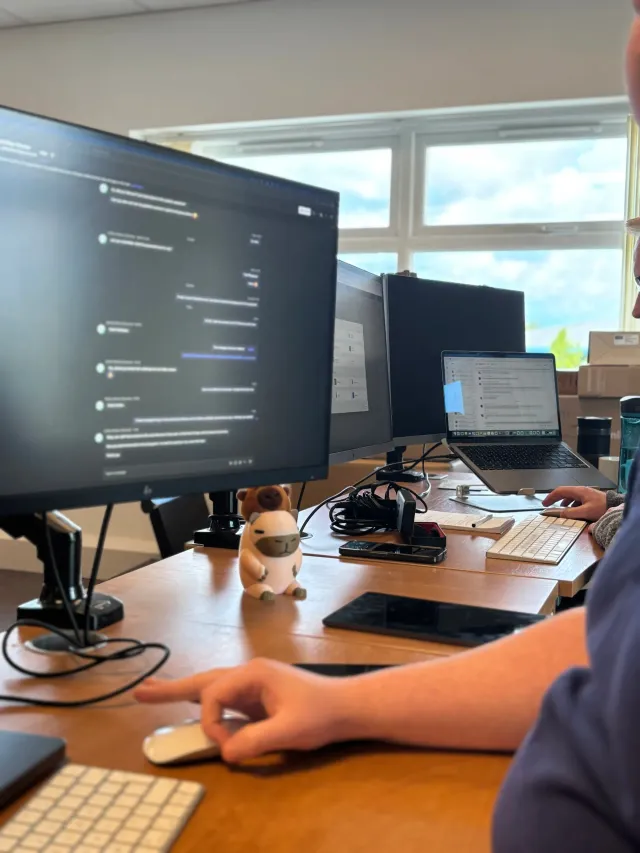A software engineer reviewing an AI project across multiple screens.